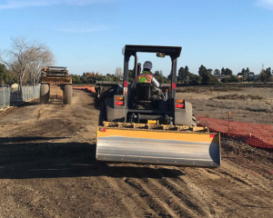 Tractor grading trail for pile insertion