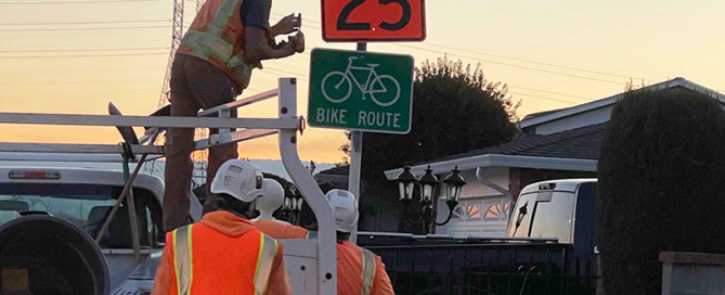 Construction crew installing speed limit sign