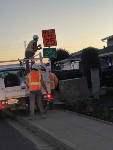Construction crew adjust speed limit sign